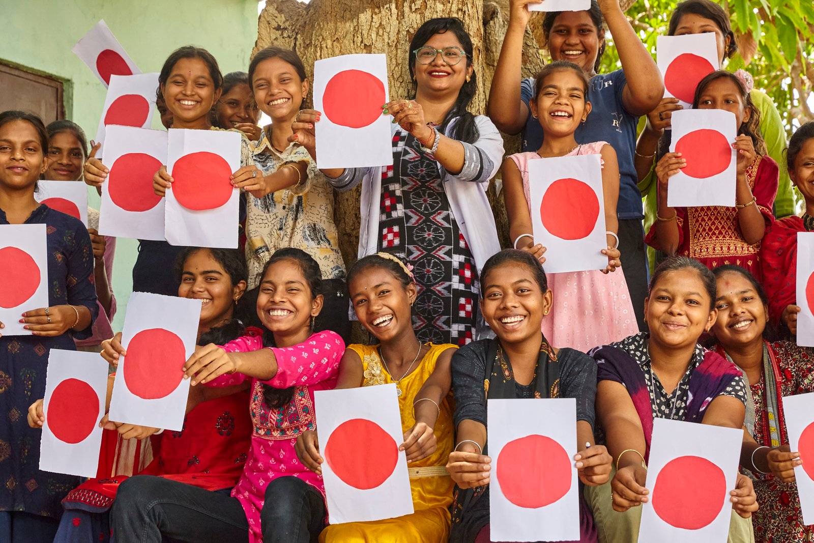 Young girls holding red dot cards — Menstrual Health Awareness